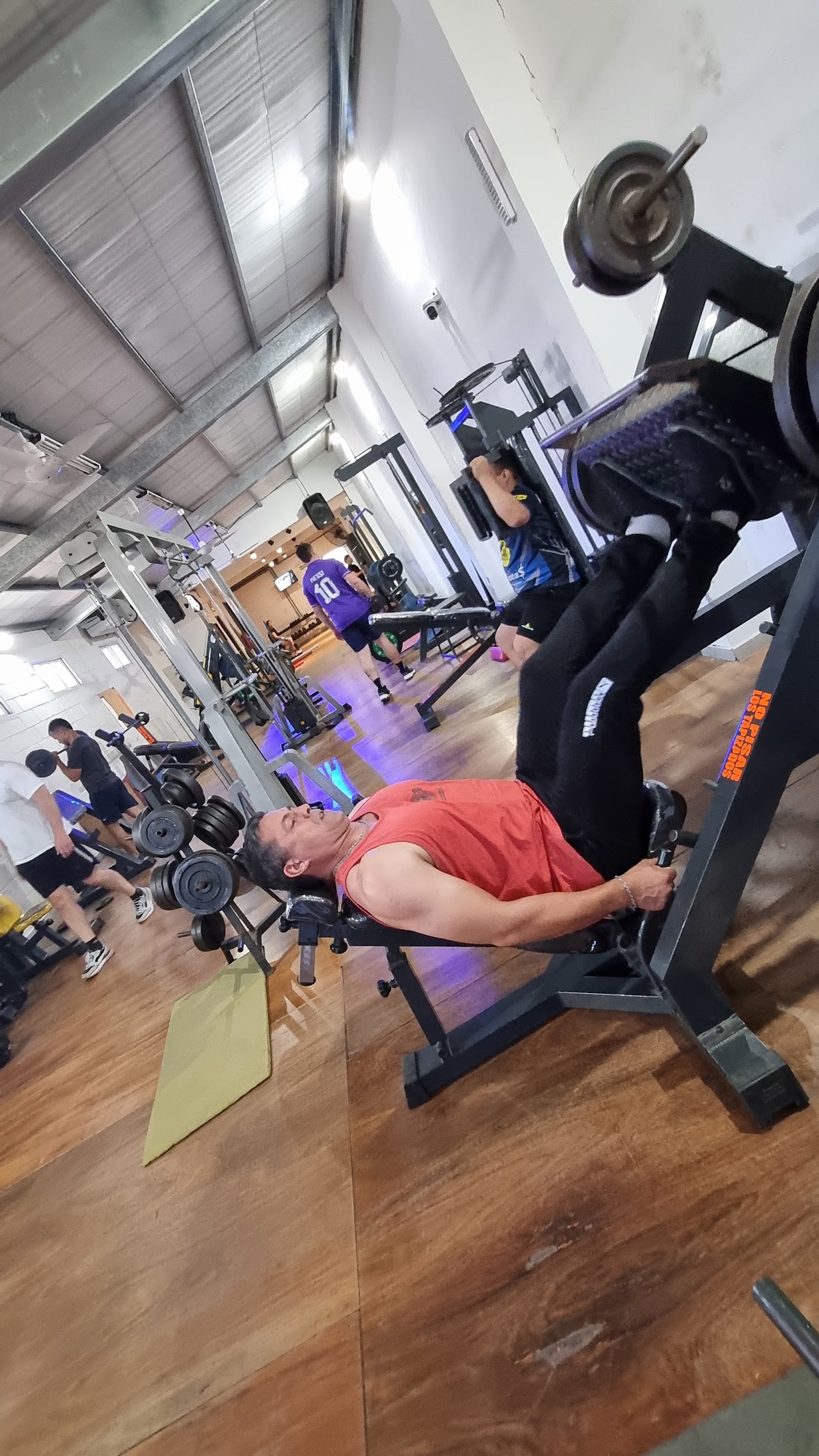 Socio entrenando en máquina de musculación en GYM FORT